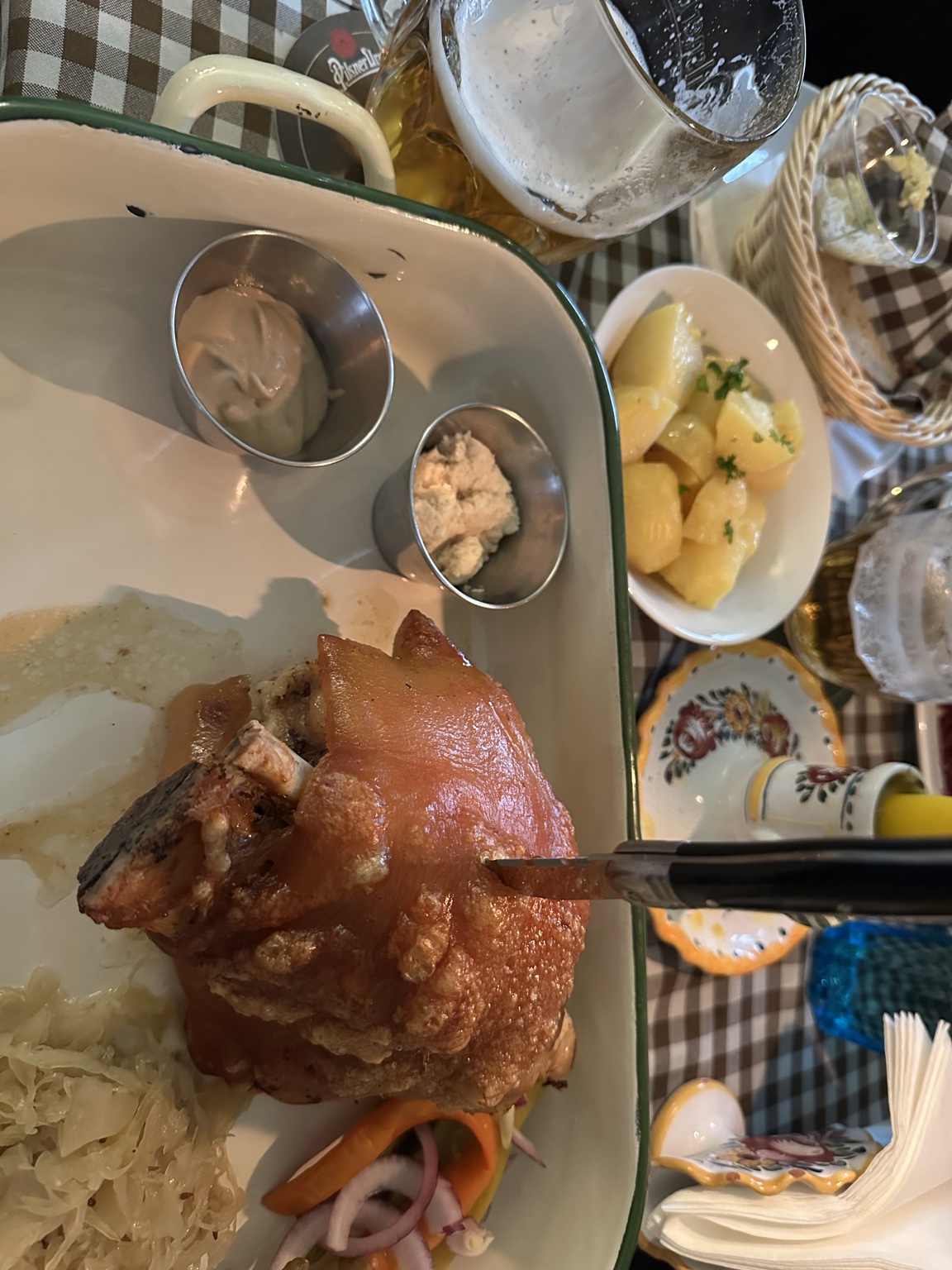 A large roasted pork knee served with bread and condiments in Prague
