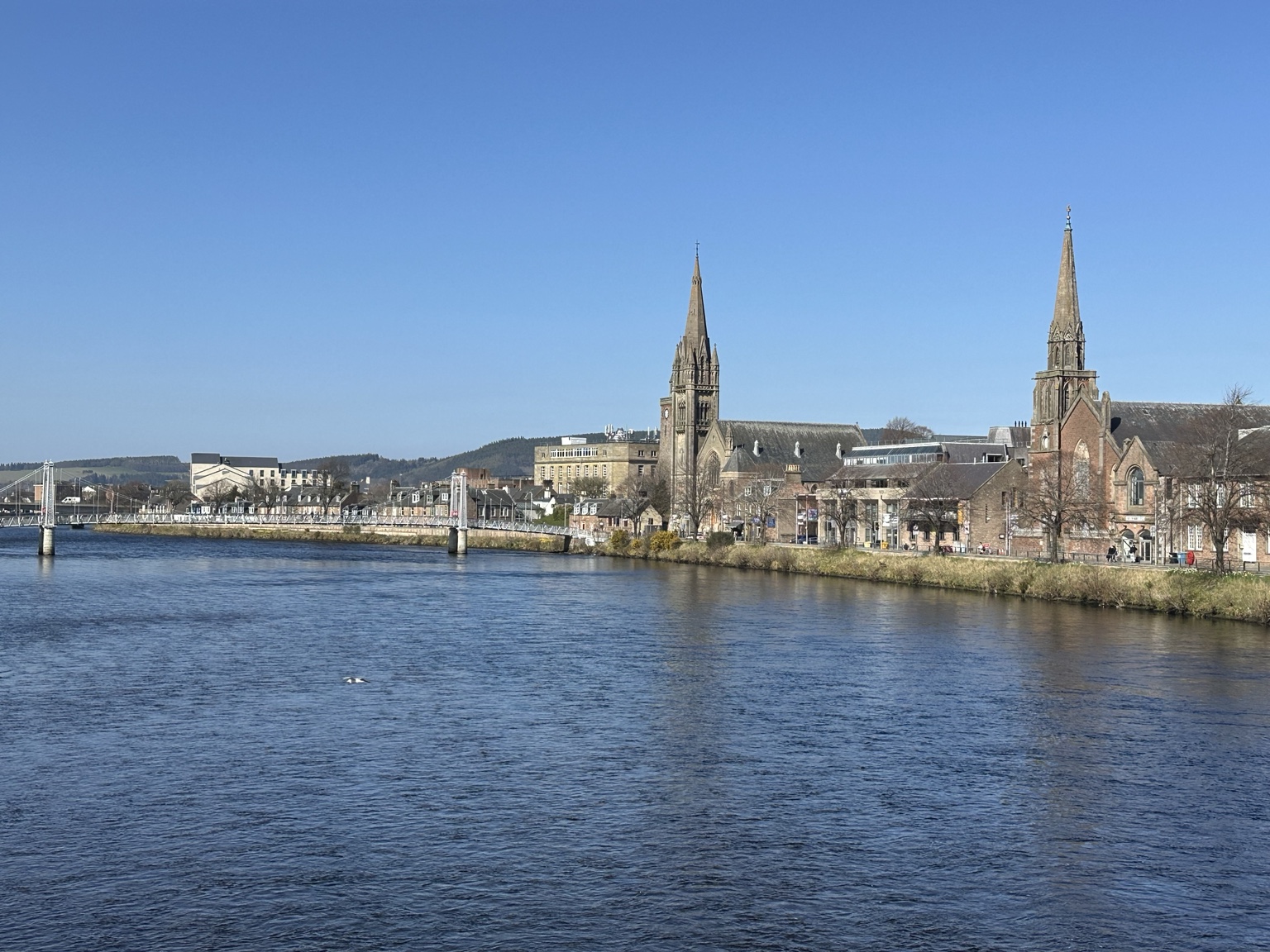 Inverness across the River Ness beneath a clear blue sky