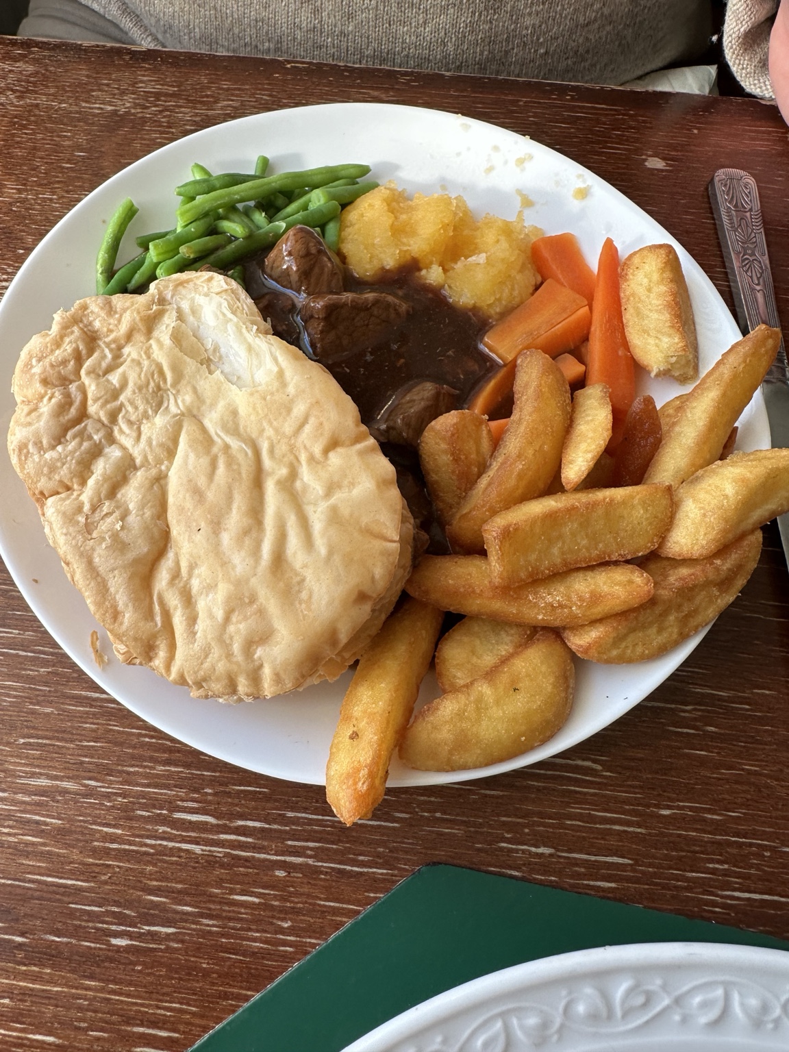 A Scottish meat pie with chips and vegetables