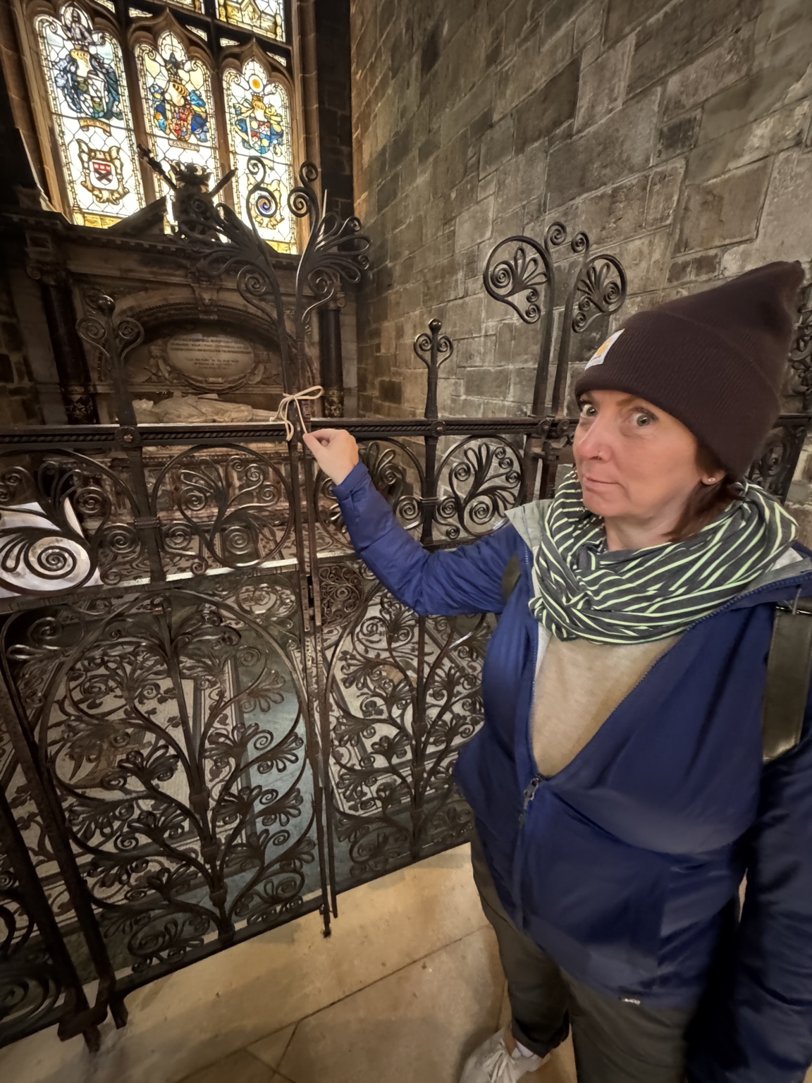 Jamie pretending to pick the lock on an ornate iron gate