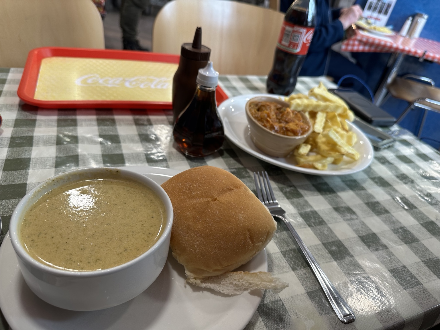 Soup and a roll with chips and beans across the table