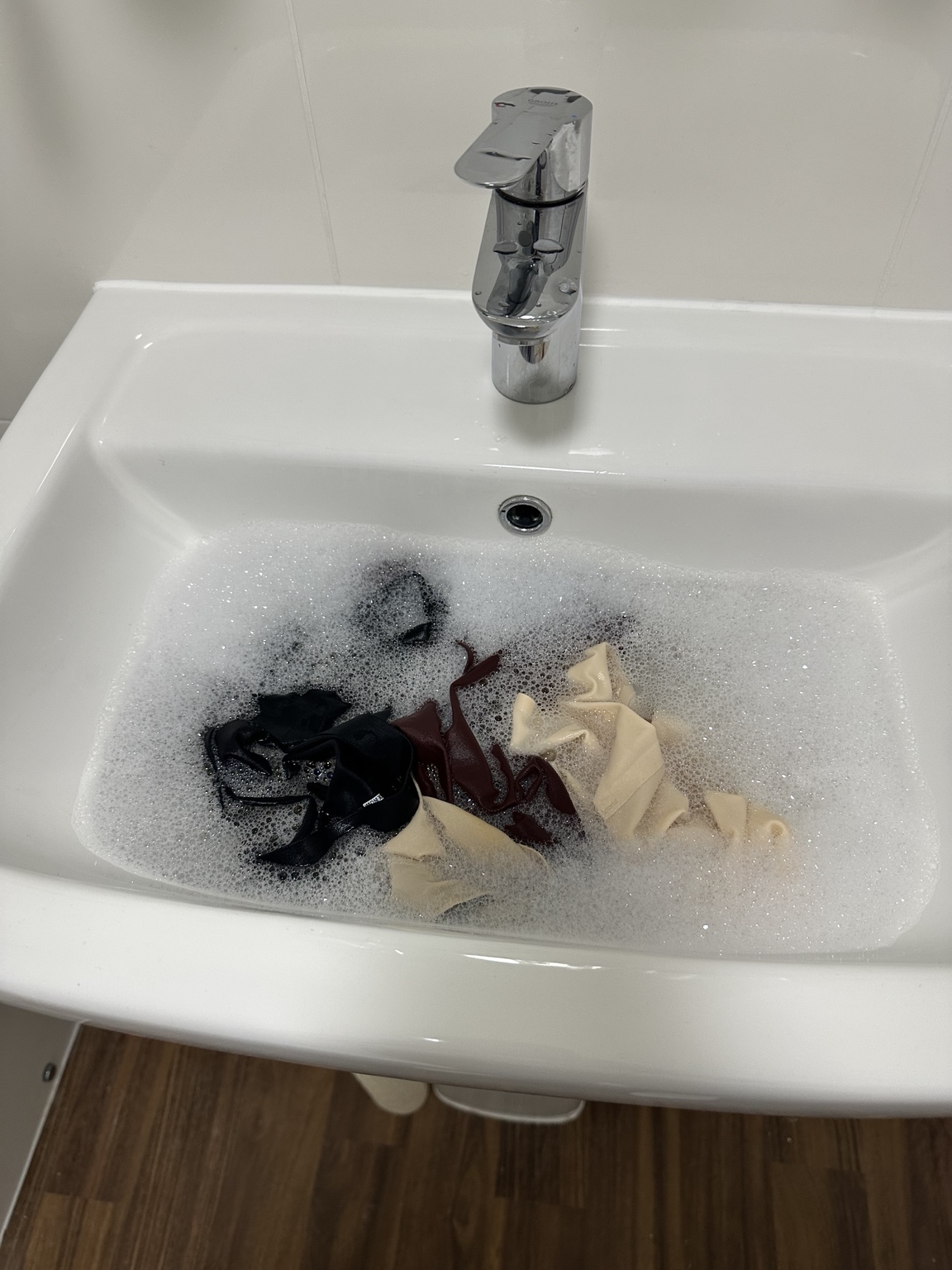 Underwear soaking in soapy water in a hotel sink